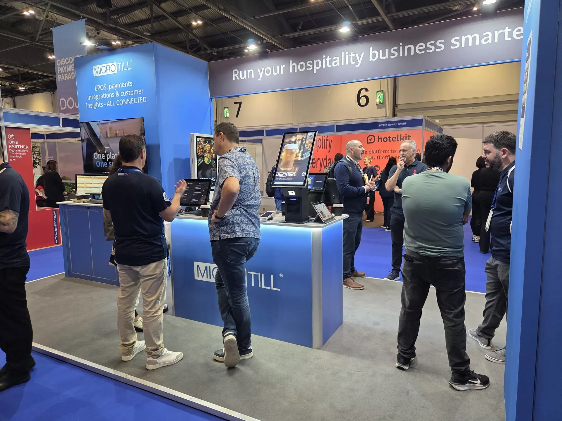 Microtill team demonstrating EPOS and self-service kiosks to visitors