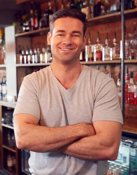 Happy business owner behind UK pub counter